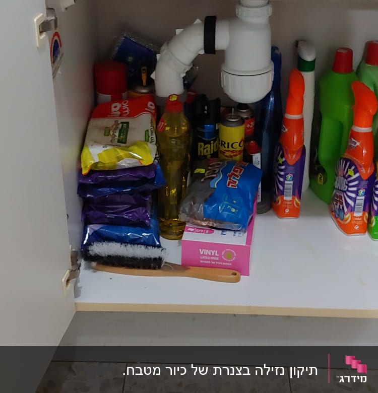 צינור ניקוז לבן מתחת לכיור במטבח
